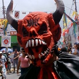 folião usando mascara de demônio na avenida do carnaval