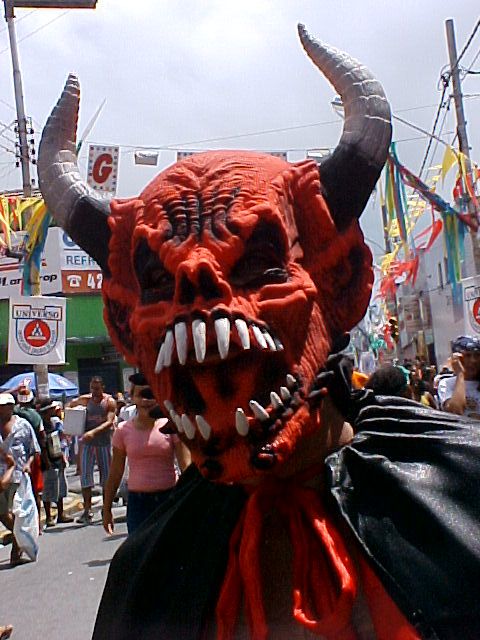 folião usando mascara de demônio na avenida do carnaval
