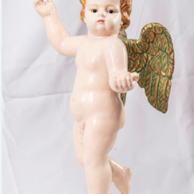Anjo branco, cachos dourados, asas dourado cobreado. Figura angelical apoiada em um dos pés, braço esquerdo a frente em sinal de cumprimento, braço direito levantada para cima.