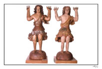 Figura de fisionomia jovem, de pé na posição frontal, cabeça ovalada, cabelos longos e encaracolados, sobrancelhas arqueadas, nariz aquilino, boca cerrada e pescoço grosso. Braços flexionados em ângulo reto, para cima, com mãos espalmadas também para cima sugerindo carregar algo. Pernas retas, corpete de um ombro só com manga de penejamento esvoaçante no lado esquerdo, acinturado com barra festonada formando sobre saia. Saiote com fendas nas pernas presas por rosetas. Pés descalços em médio afastamento. Parte de trás seguindo o padrão escultórico da parte frontal porém em caimento reto. Local para fixação de asas. Base arredondada